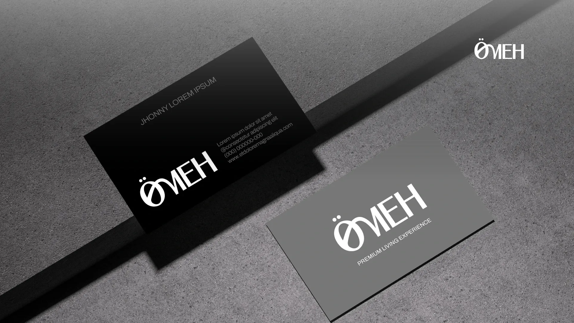 Ömeh business cards, one black and one grey, with the logo in white